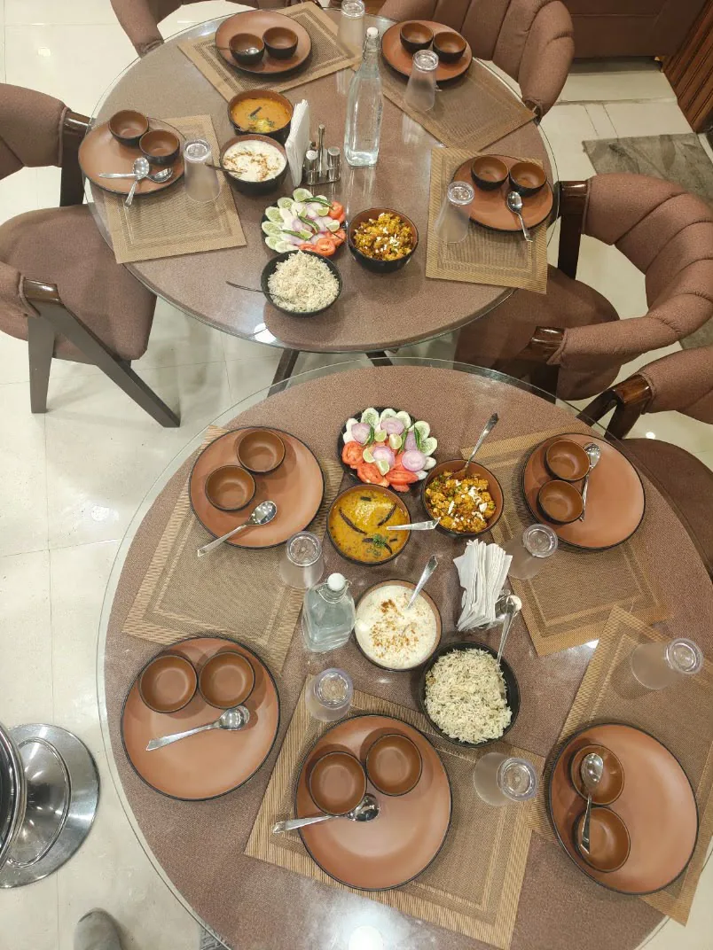 Authentic Sattvic dining spread with fresh salad, dal, rice, and raita
